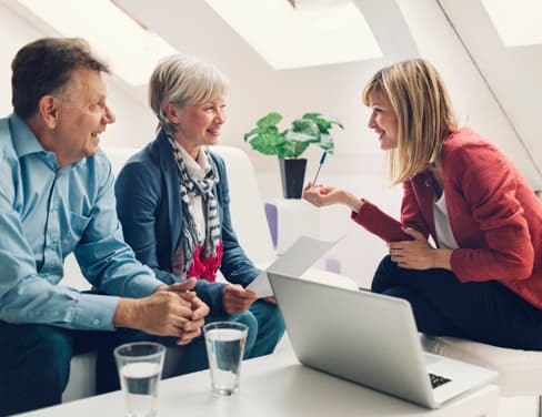 Ricoh professional providing advice to older couple with laptop in front