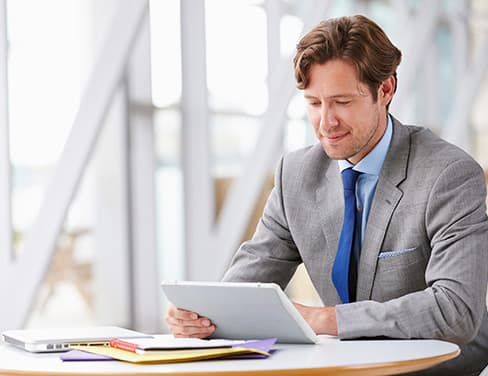 Man in suit at desk with tablet